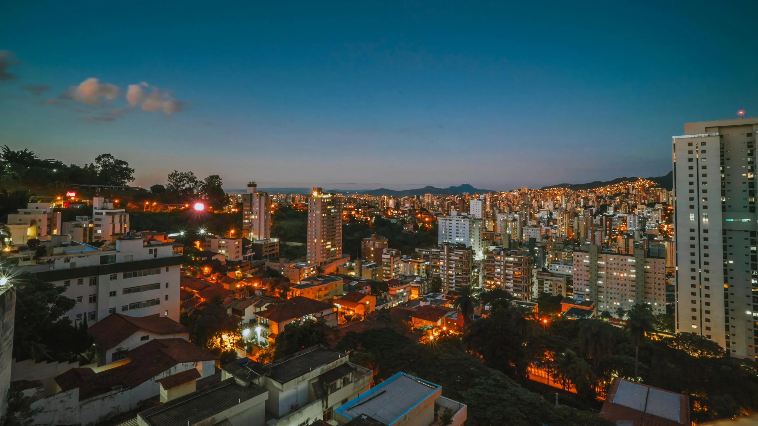 Vista panorâmica de Belo Horizonte, destacando a Lagoa da Pampulha e a arquitetura moderna, reforçando sua hospitalidade e qualidade de vida.